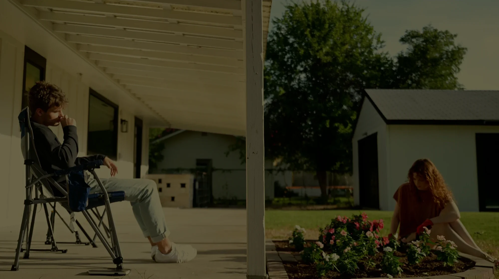 Malachi on the porch while Ven gardens — still from ‘Ven