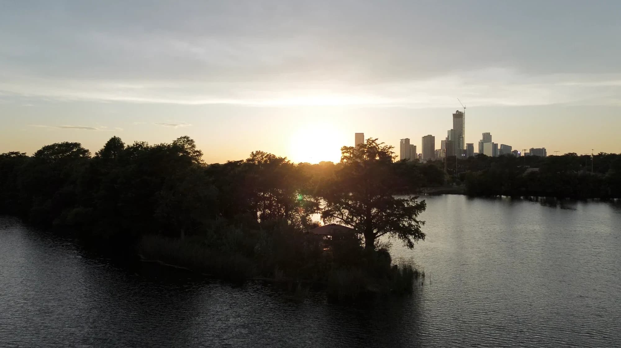 Sunset over the lake and the city skyline — still from ‘Ven